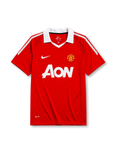 Manchester United 2010-11 home jersey, front view, red body with white shoulder pinstripes, white point collar, Nike swoosh logo, club crest, AON sponsor logo