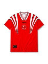 Turkey 1996 Euro home jersey, front view, red body with white angular shoulder streaks, striped V-neck collar, adidas wordmark, Turkish Football Federation crest