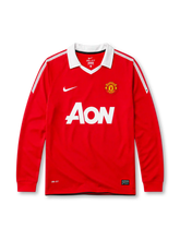 Manchester United 2010-11 home long sleeve jersey, front view, red body with white shoulder and sleeve pinstripes, white point collar, Nike swoosh logo, club crest, AON sponsor logo