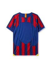 Barcelona 2005-06 home jersey, front view, blue and garnet vertical stripes, crew neck collar with Catalan flag tab, Nike swoosh logo, club crest, yellow side panels