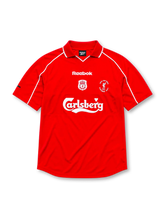 Liverpool 2000-01 home jersey, front view, red body with white piping on raglan sleeves, white polo-style collar, white Reebok logo, Liverpool club crest, circular UEFA Cup Final Dortmund 2001 patch, white Carlsberg sponsor logo