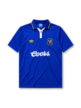 Chelsea 1995-97 home jersey, front view, royal blue body, white polo-style collar with yellow trim and button placket, yellow Umbro logo, blue and yellow Chelsea shield crest with lion, white Coors script sponsor logo