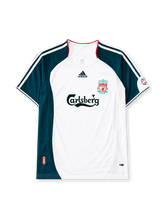 Liverpool 2006-08 away jersey, front view, white body with dark teal raglan sleeve and side panels, red piped collar, white adidas logo and stripes, Liverpool shield crest, black Carlsberg script sponsor logo, small tournament emblem on sleeve