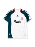 Liverpool 2006-08 away jersey, front view, white body with dark teal raglan sleeve and side panels, red piped collar, white adidas logo and stripes, Liverpool shield crest, black Carlsberg script sponsor logo, small tournament emblem on sleeve