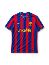 Barcelona 2009-10 home jersey, front view, blue and garnet vertical stripes, yellow-trimmed V-neck collar, white Nike swoosh, Barcelona crest, yellow unicef sponsor logo with globe emblem, yellow cuff trim