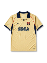 Arsenal 2001-02 away jersey, front view, gold body with navy side panels and red piping, navy V-neck collar, white Nike swoosh, Arsenal shield crest with cannon, navy Sega sponsor logo, navy cuffs