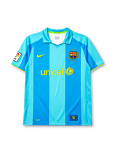 Barcelona 2007-08 away jersey, front view, two-tone sky blue vertical stripes, polo-style collar with green trim, yellow Nike swoosh, Camp Nou 1957-2007 anniversary crest, yellow unicef sponsor logo, La Liga patch on sleeve