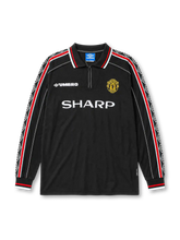 Manchester United 1998-99 third long-sleeve jersey, front view, black body, black white and red diamond pattern trim on long sleeves, black polo-style collar with zip placket, white Umbro logo, Manchester United devil crest, white Sharp sponsor logo