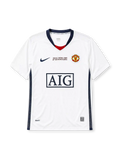 Manchester United 2008-09 away jersey, front view, white body with navy side panels, navy V-neck collar with red inset and United text, navy Nike swoosh, Final Roma 2009 commemorative text, Manchester United crest, boxed AIG sponsor logo