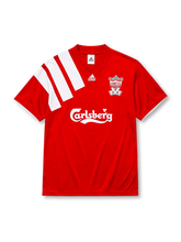 Liverpool 1992-93 home jersey, front view, red body with bold diagonal white shoulder stripe, V-neck collar, adidas Equipment logo, centenary crest reading Liverpool Football Club 100 Years 1892-1992, white Carlsberg script sponsor logo