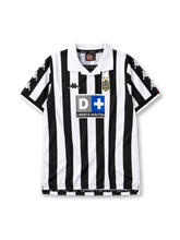 Juventus 1999-00 home jersey, front view, black and white vertical stripes, white polo collar with black V insert, repeating white Kappa logos on black sleeve panels, Kappa logo on right chest, oval Juventus crest with two gold stars on left chest, D+ Liberta Digitale sponsor logo, white cuffs with black trim, split side vents