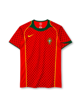 Portugal 2004 home jersey, front view, red body with tonal dark red cross-motif pattern, green crew neck and collar yoke, yellow piping down the front, yellow Nike swoosh on right chest, Portuguese Football Federation crest on left chest, green sleeve cuffs