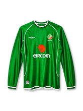 Republic of Ireland 2002 home long sleeve jersey, front view, green ribbed body, green crew neck with white and navy stripes, white raglan piping, long sleeves with striped cuffs, white Umbro logo on right chest, FAI crest with IRELAND text on left chest, EIRCOM sponsor logo, white hem binding