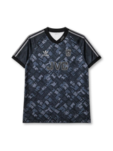Arsenal 1990-92 away jersey, front view, dark charcoal body with diagonal blue-grey abstract pattern, black V-neck collar with AFC script, black sleeves with three grey stripes, grey adidas trefoil logo on right chest, monochrome Arsenal cannon crest on left chest, JVC sponsor lettering, black ribbed cuffs