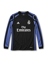 Real Madrid 2016-17 third long sleeve jersey, front view, black body, black V-neck collar, purple raglan shoulders with curved arc graphics, long sleeves with purple and black stripes, purple three stripes down the sides, white adidas logo on right chest, monochrome Real Madrid crest on left chest, white FLY EMIRATES sponsor lettering