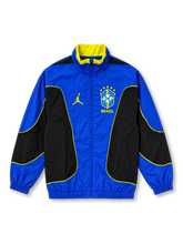 Brazil 2026 Jordan National Team track jacket in royal blue and black with yellow piping, featuring a high stand-up collar, full front zipper, yellow Jumpman logo, and five-star CBF crest.