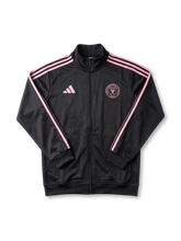 Inter Miami CF adidas track jacket in black with pink Three Stripes on sleeves, pink adidas logo at left chest, tonal pink circular Inter Miami CF crest at right chest, ribbed collar and cuffs, twin zip pockets