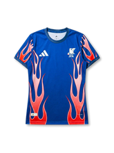 Japan national team adidas 2026/27 Sacred Flame Special Edition Authentic (Player Issue) jersey in royal blue with red and white flame graphics rising from hem and sleeves, white adidas Three Bars logo at left chest, JFA eagle crest at right chest, teal-navy collar