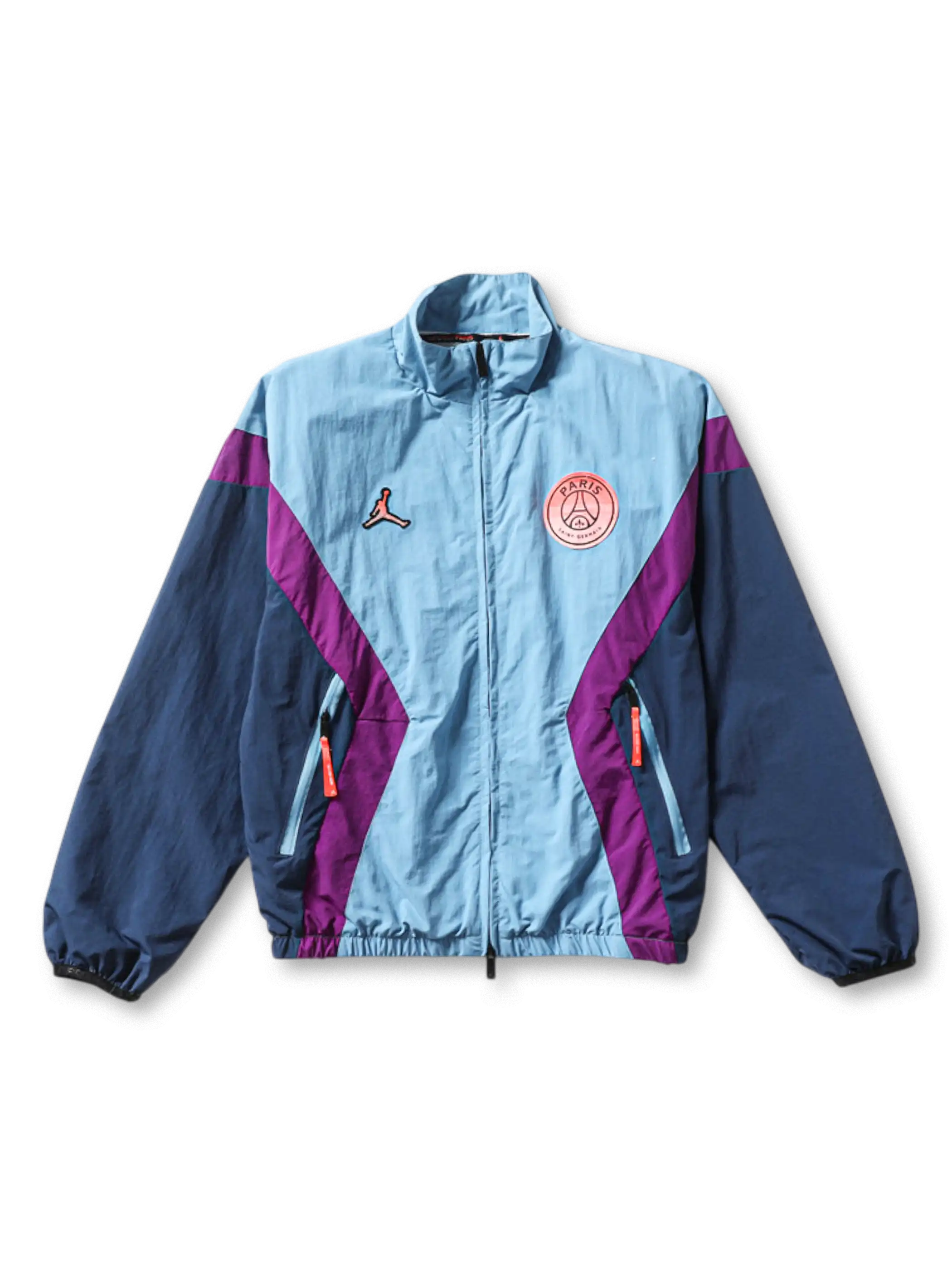 Paris Saint-Germain × Jordan Brand track jacket in ice blue with diagonal purple chevron panels, Jumpman logo at left chest, coral PSG crest badge at right chest, navy sleeves