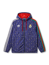 Real Madrid × adidas × Gucci 2022 navy hooded jacket with allover GG, Trefoil, and Real Madrid crest monogram print in gold, Three Stripes on left sleeve, Gucci Web stripe on right, red hood lining visible