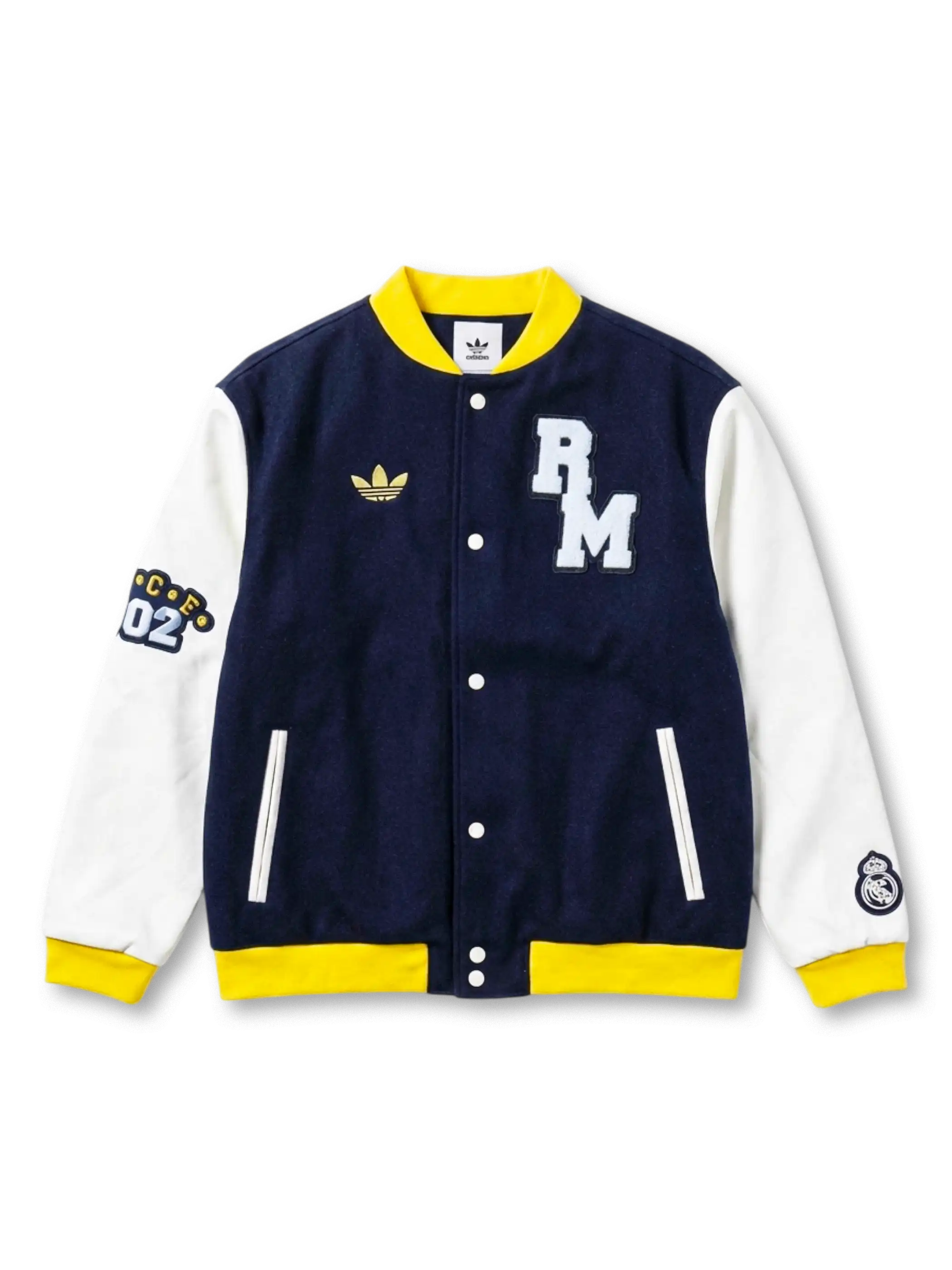 Real Madrid adidas Originals varsity jacket with navy wool body, white leather sleeves, yellow ribbed trim, chenille RM chest patch, gold Trefoil, CE02 sleeve patch, and Real Madrid crest on right sleeve