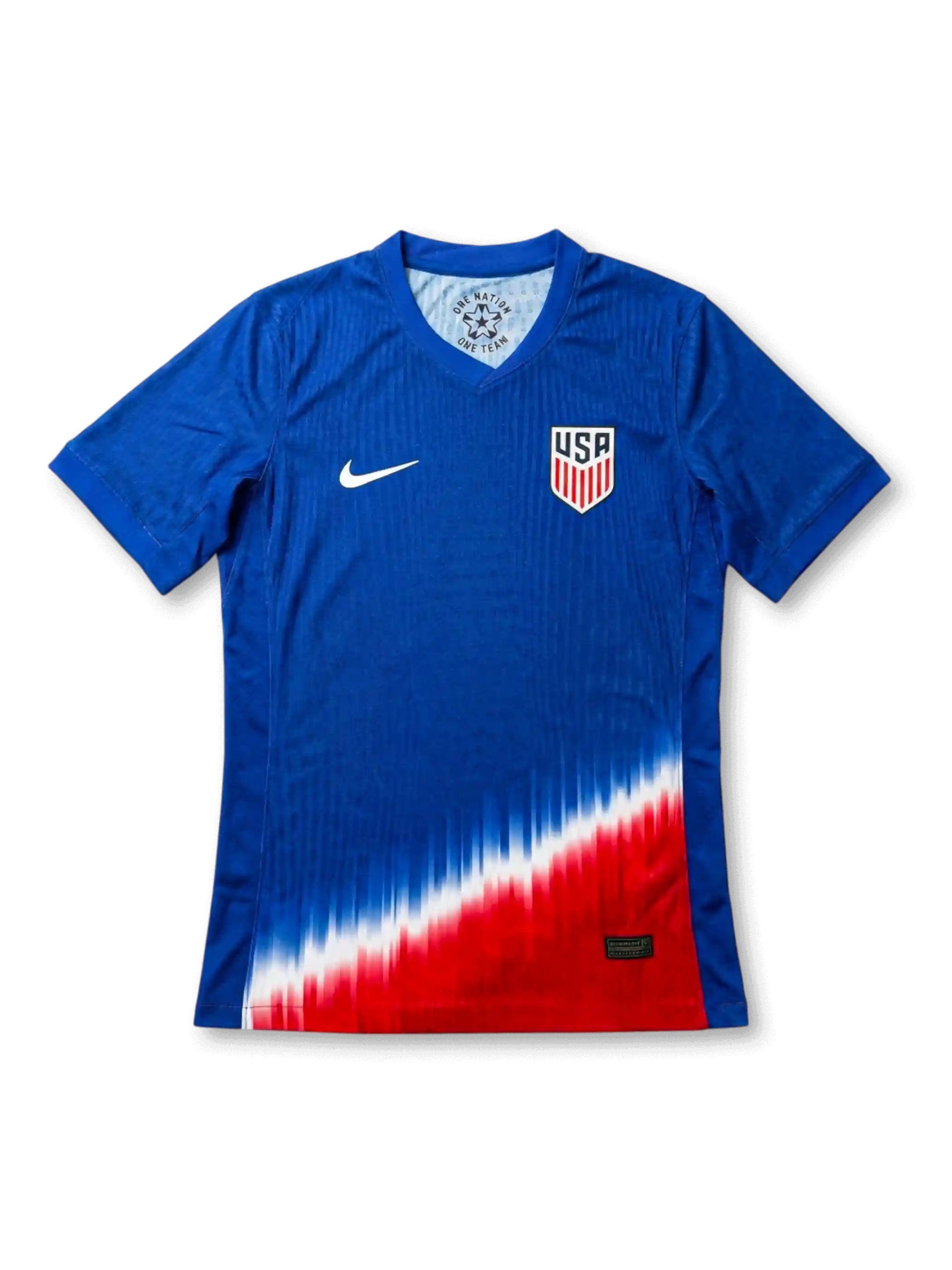 USA national team Nike 2024/25 away jersey in royal blue with tonal vertical pinstripe texture, dramatic diagonal red, white, and blue gradient fade at hem, white Swoosh at left chest, USA shield crest at right chest
