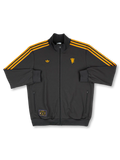 2025/26 Manchester United adidas Originals Icon short-sleeve track top in black with amber gold Three Stripes, gold standalone red devil crest at right chest, gold Trefoil at left chest, twin zip side pockets, and co-branded woven label at hem