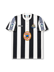 Front view of Newcastle United 1995-97 home shirt with black-and-white stripes, Newcastle Brown Ale sponsor, club crest, buttoned collar, and Premier League sleeve patches.