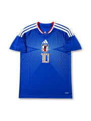 Front view of Japan 2006 Captain Tsubasa home shirt with blue body, Japan crest, white line graphics, #10 manga-style chest number, and red collar trim.