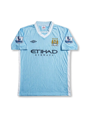 Front view of Manchester City 2011-12 home jersey with sky blue body, Etihad Airways sponsor, club crest, and Barclays sleeve patches.