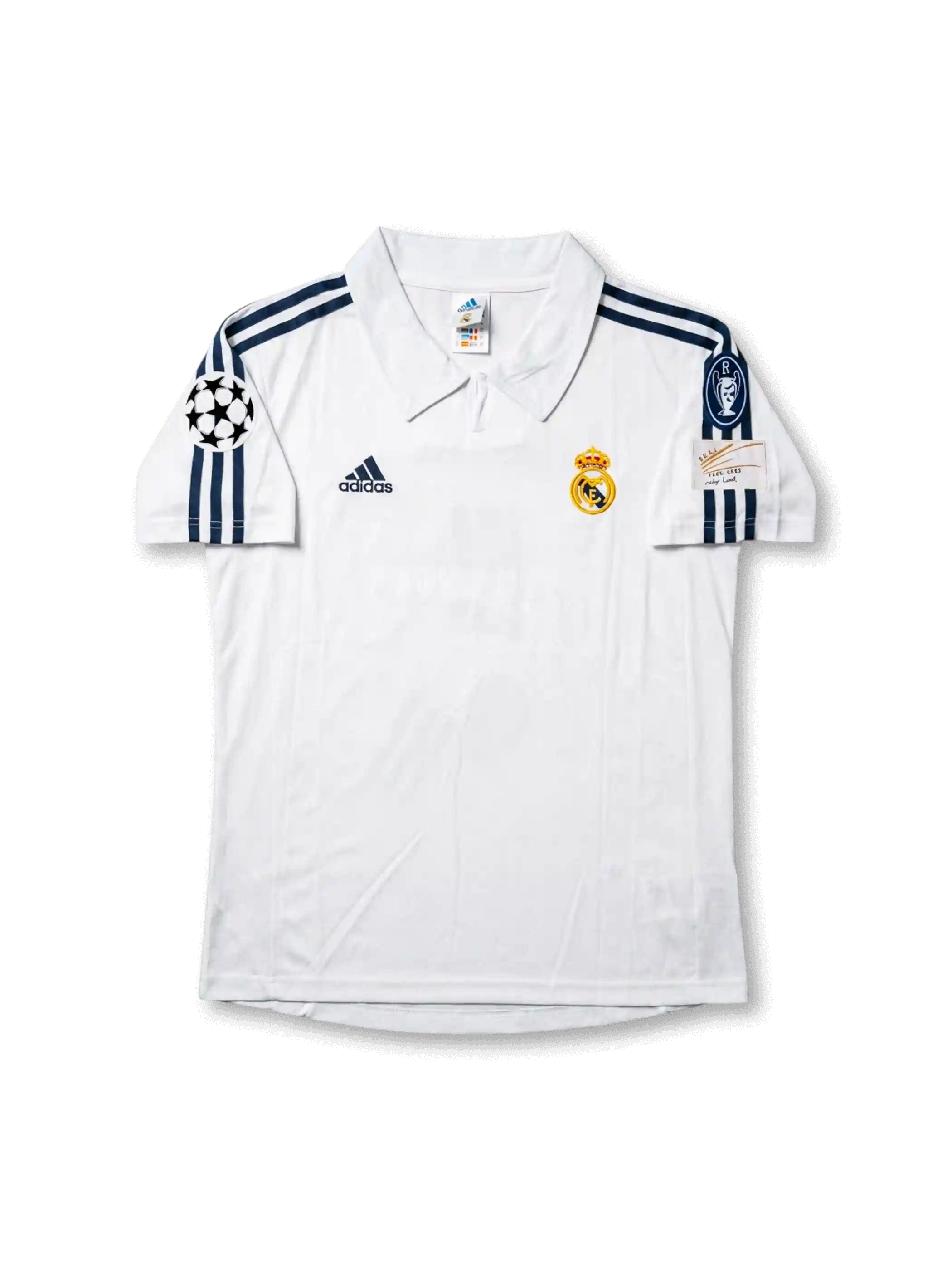 Front view of Real Madrid 1998-00 home shirt with white base, club crest, dark navy shoulder stripes, and Champions League sleeve patch.