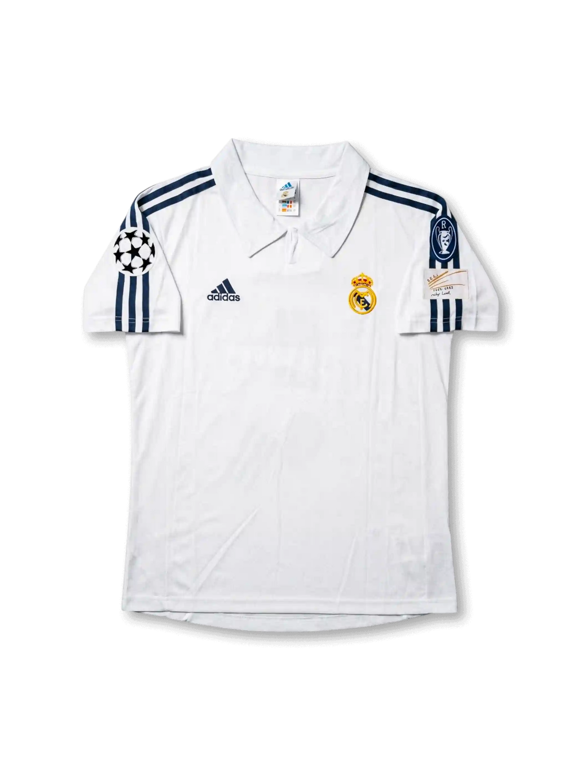 Front view of Real Madrid 1998-00 home shirt with white base, club crest, dark navy shoulder stripes, and Champions League sleeve patch.