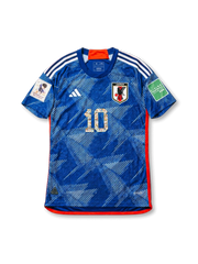 Front view of Japan 2022 Captain Tsubasa collaboration shirt with blue angular graphic design, Japan crest, illustrated #10 detail, red trim, and sleeve patches.