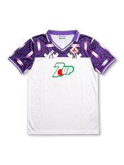 front view of Fiorentina 1992-93 away shirt with white body, purple shoulder graphics, 7UP sponsor, Lotto branding, and Fiorentina crest