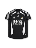 Real Madrid 2006-07 away jersey featuring David Beckham #23, black adidas soccer shirt with white three-stripe shoulder detailing, curved white side panels, white-trimmed crew neck collar, BenQ Siemens sponsor logo, Real Madrid club crest, FIFA Best Club of the 20th Century commemorative badge, and BECKHAM name with white number 23 on the back.