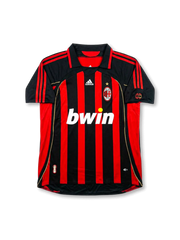 Front view of AC Milan home shirt in black and red stripes with bwin sponsor, adidas logo, club crest, gold star, and sleeve patches.