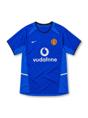 Manchester United 2002/03 royal-blue third jersey with lighter blue side panels, black-trimmed round collar, white Nike Swoosh, club crest and white Vodafone sponsor.