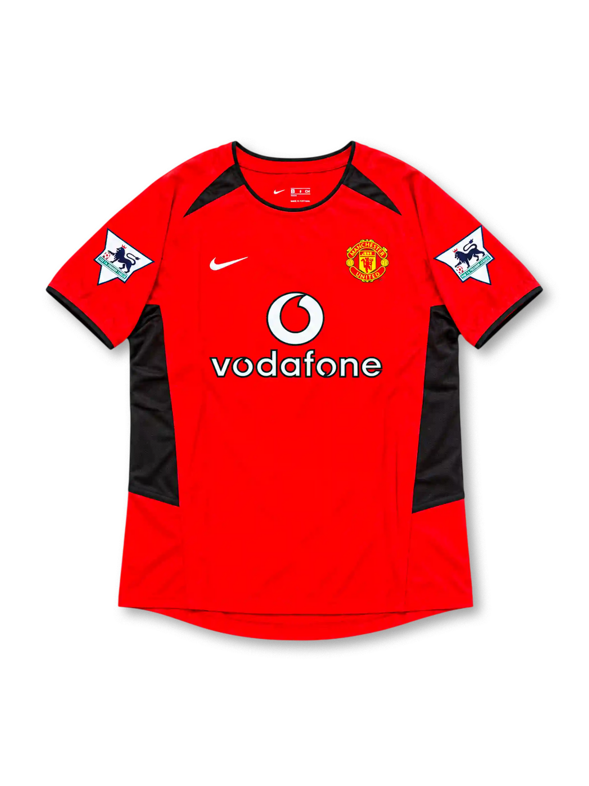 Manchester United 2002-04 home jersey by Nike, featuring a classic red soccer shirt with a black crew neck collar, black sleeve trim, angular black shoulder and side panels, white Nike Swoosh, Vodafone sponsor logo, and Manchester United club crest, representing the 2002-03 and 2003-04 seasons.