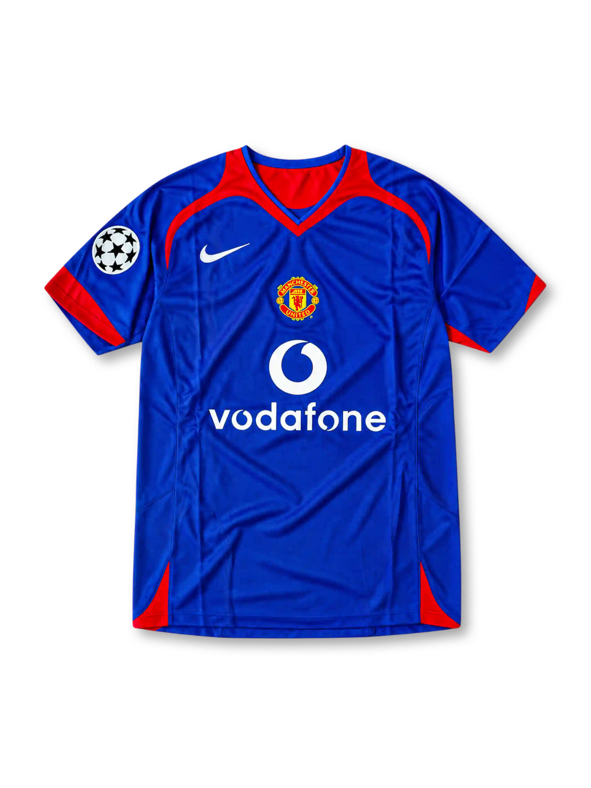 Front view of the 2005/06 Manchester United blue away soccer jersey by Nike, featuring red shoulder accents, a central club crest, white Vodafone sponsor, and UEFA Champions League sleeve patch.