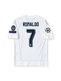 Front view of the Real Madrid 2015/16 white home soccer jersey featuring silver adidas shoulder stripes, dark navy Fly Emirates sponsor, crowned club crest, UEFA Champions League starball patch, 10-time European Cup winners badge, and UEFA Respect sleeve patch.