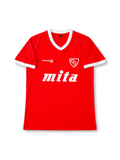 Front view of the Club Atlético Independiente 1984-85 red home football shirt associated with number 10 Ricardo Bochini, featuring a white V-neck collar and sleeve cuffs, white Topper logo, Independiente crest, and large white Mita sponsor graphic.