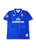Front view of a royal blue Fiorentina Reebok football shirt associated with Gabriel Batistuta #9, featuring a red and white trimmed polo collar, Fiorentina crest, Reebok logo, Sammontana chest sponsor, and Serie A sleeve patch.
