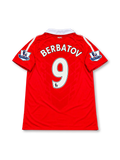 Front view of the Manchester United 2010-11 Nike home soccer jersey in red with a white polo collar, white Nike Swoosh, Manchester United crest, Aon chest sponsor, and Barclays Premier League sleeve patches.