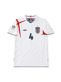 England 2005-07 white Umbro home jersey featuring asymmetric red St George's Cross detailing, navy trim, Three Lions crest, Germany 2006 World Cup sleeve patch and Steven Gerrard number 4.