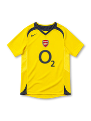 Arsenal 2005/06 yellow away jersey with charcoal V-neck collar, Nike Swoosh, Arsenal crest, O2 sponsor and curved shoulder panels.