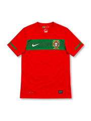 Portugal 2010 red Nike home jersey with a textured green horizontal chest band, white Nike Swoosh, Portuguese Football Federation crest, green sleeve accents, Dri-FIT lettering, and black Authentic-style hem label.