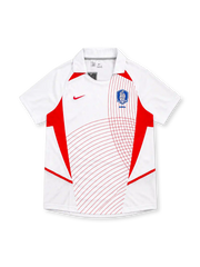 South Korea 2002 Nike away jersey in white with red geometric side panels, curved red pinstripe graphics, white fold-down collar, red Nike Swoosh, and blue Korea Football Association crest.