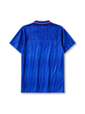 Chelsea 1989-91 home jersey, front view, royal blue body with diagonal jacquard texture, striped point collar, two-button placket, Umbro diamond logo, club lion crest, Commodore sponsor logo