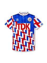 Ajax 1989-90 away jersey, front view, blue upper body with pinstripes, red white and blue geometric chevron pattern on lower body and sleeves, striped funnel collar, Umbro diamond logo, club crest, TDK sponsor logo