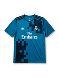 Real Madrid 2017-18 third jersey, front view, teal body with pixelated navy gradient pattern, adidas three-stripe shoulder detailing, crew neck collar, adidas logo, club crest, Fly Emirates sponsor logo, Climacool label